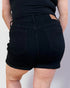 Person wearing black shorts on a plain background