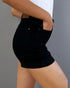 Person wearing black shorts on a gray background