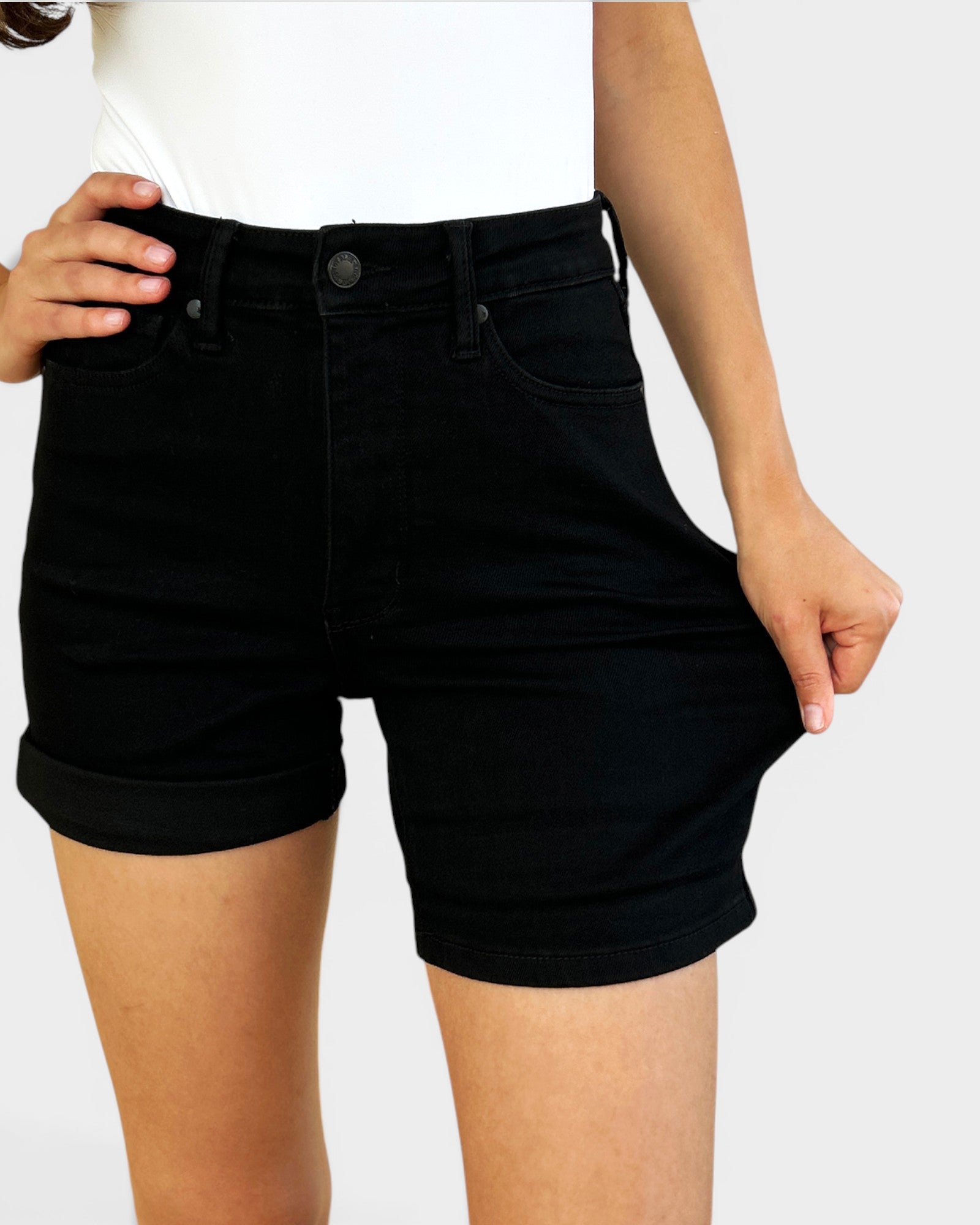 Person wearing black shorts on a plain background
