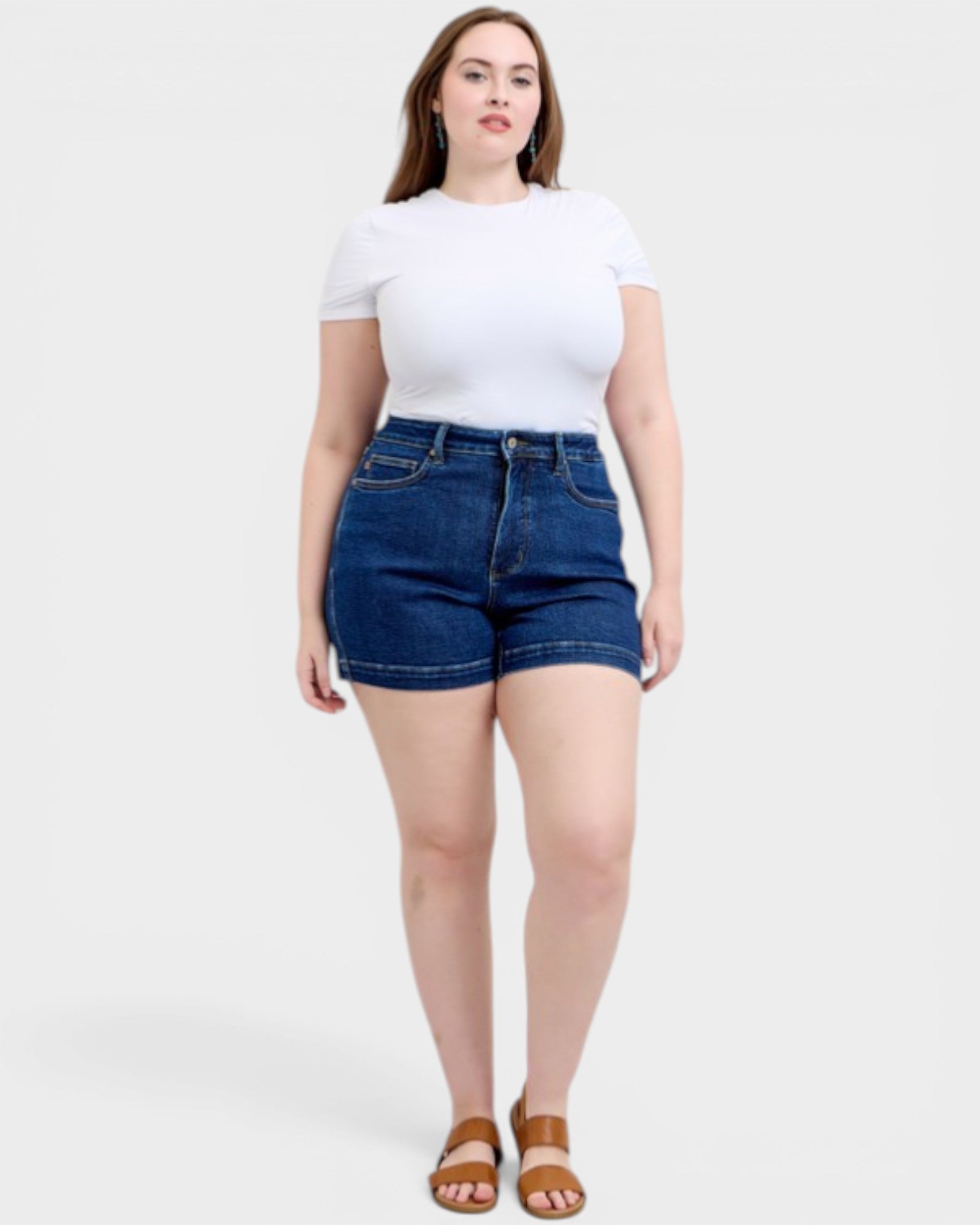 Woman wearing a white t-shirt and blue denim shorts on a white background