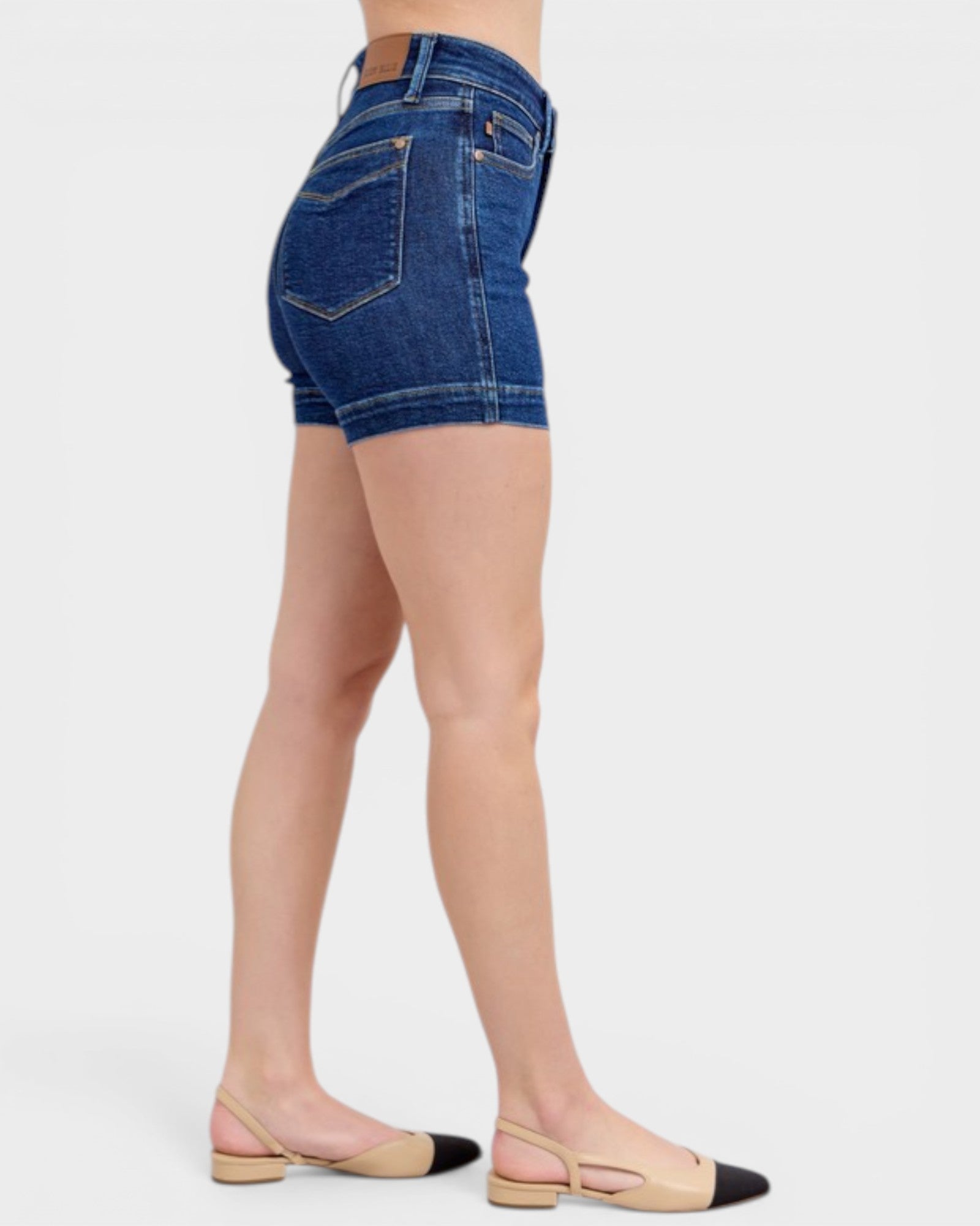 Denim shorts worn by a person on a white background
