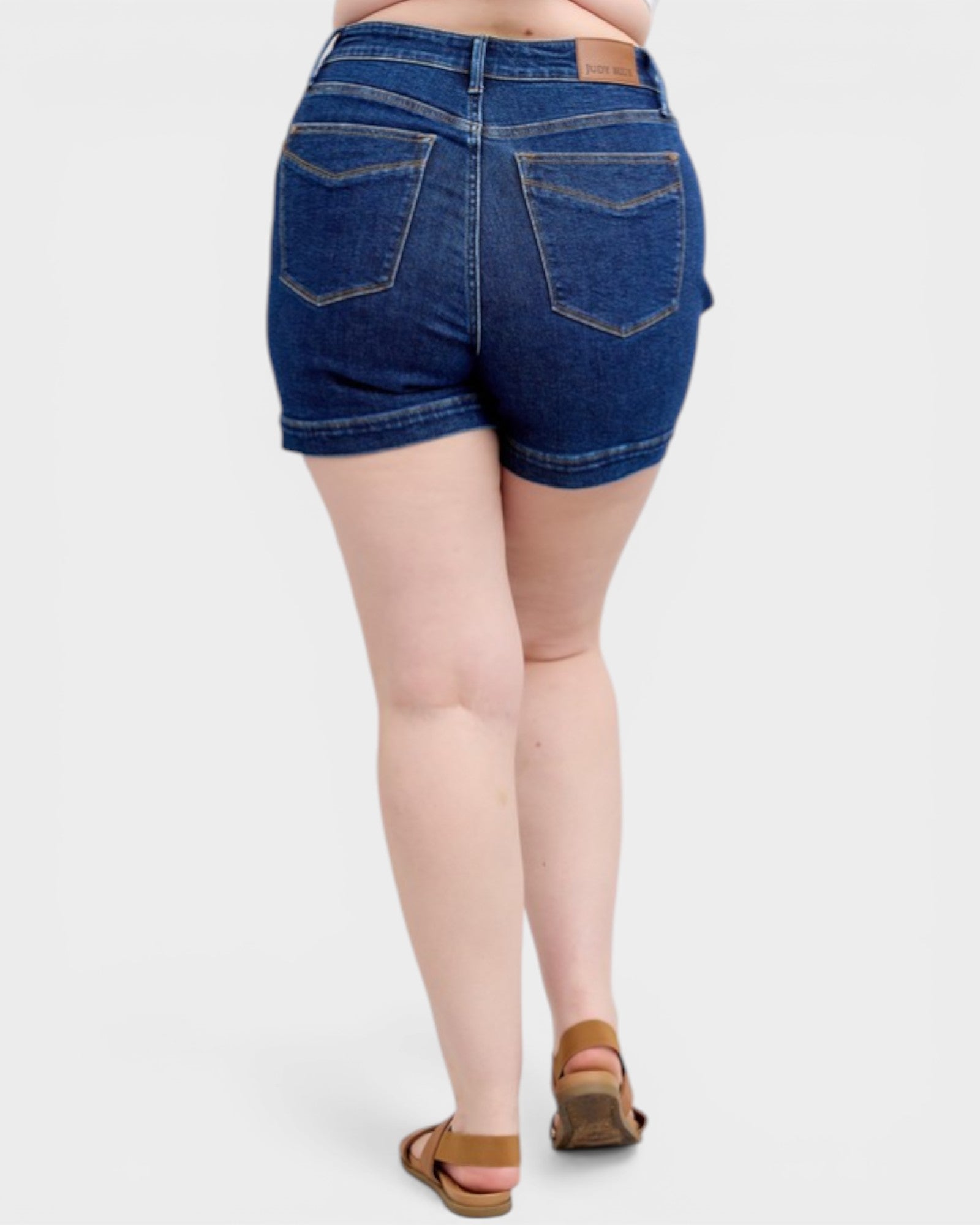 Person wearing blue denim shorts on a white background