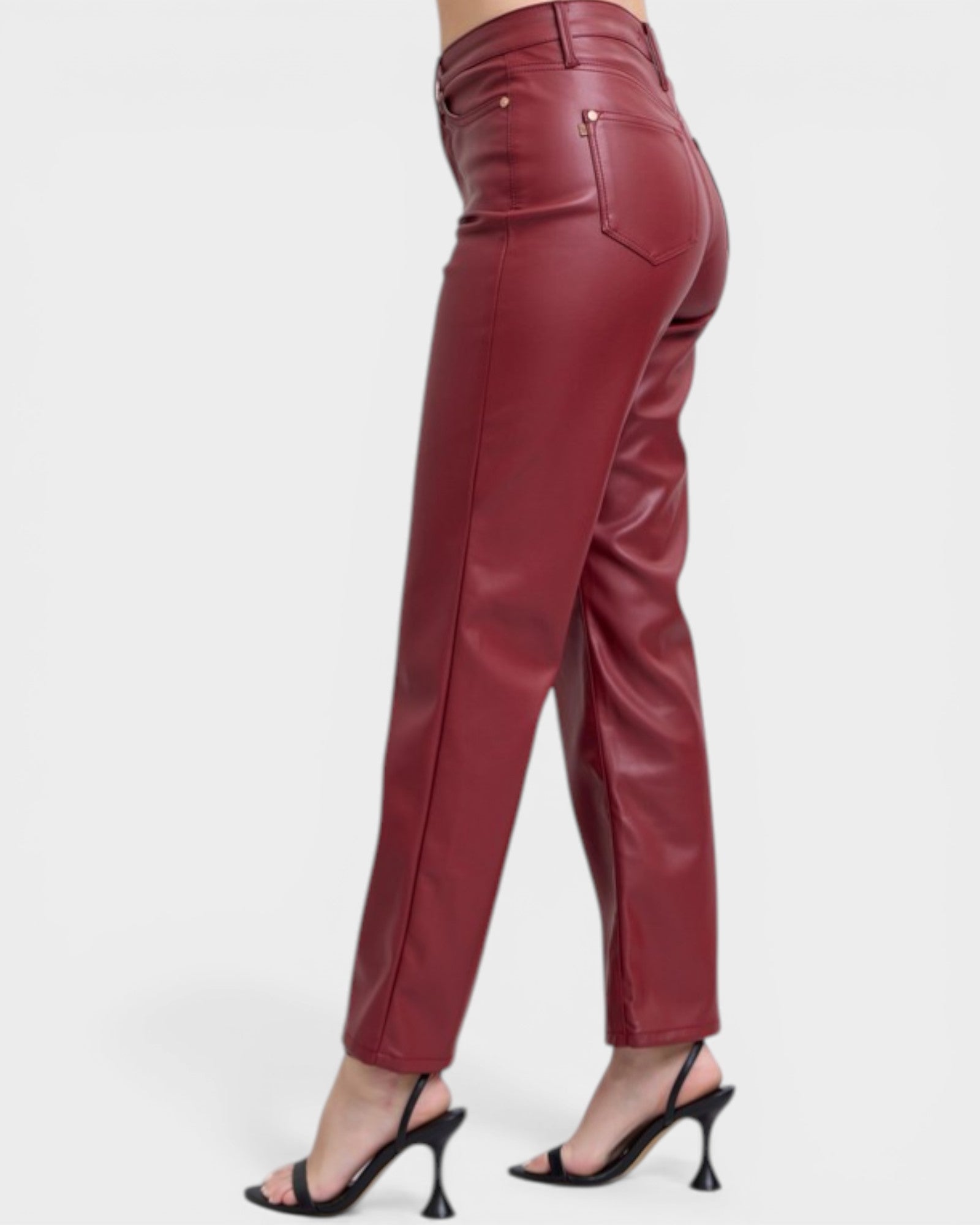 Maroon leather pants worn by a person on a white background