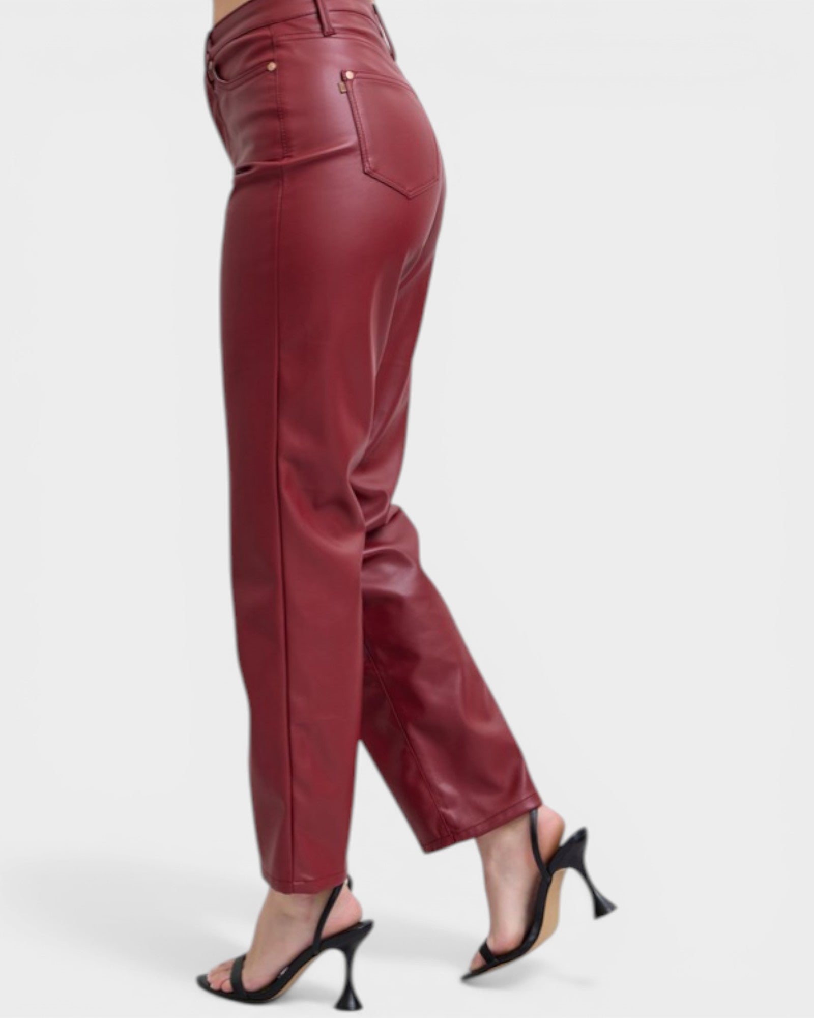Maroon leather pants worn by a person on a white background