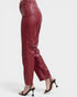 Maroon leather pants worn by a person on a white background