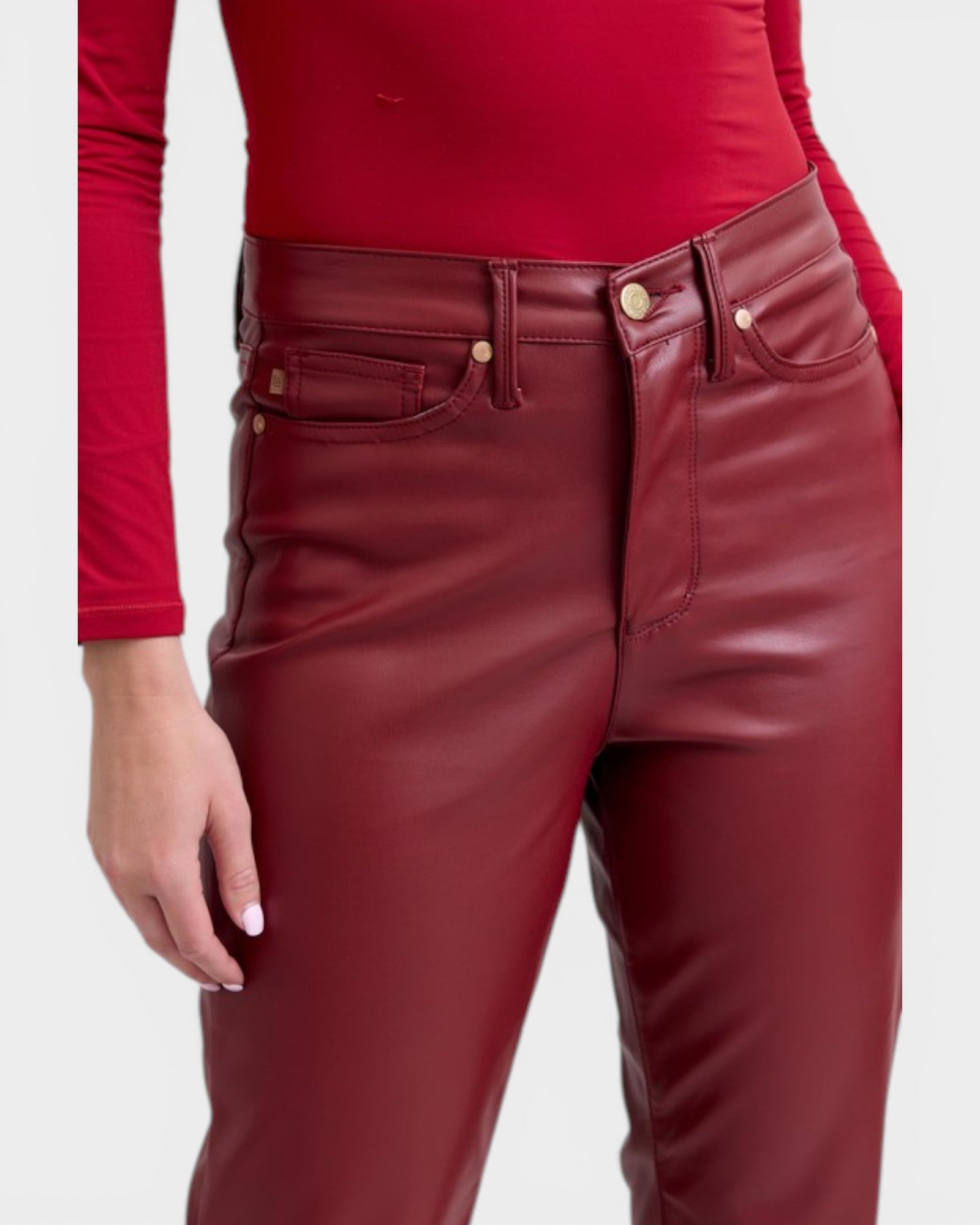 Red leather pants worn by a person on a white background