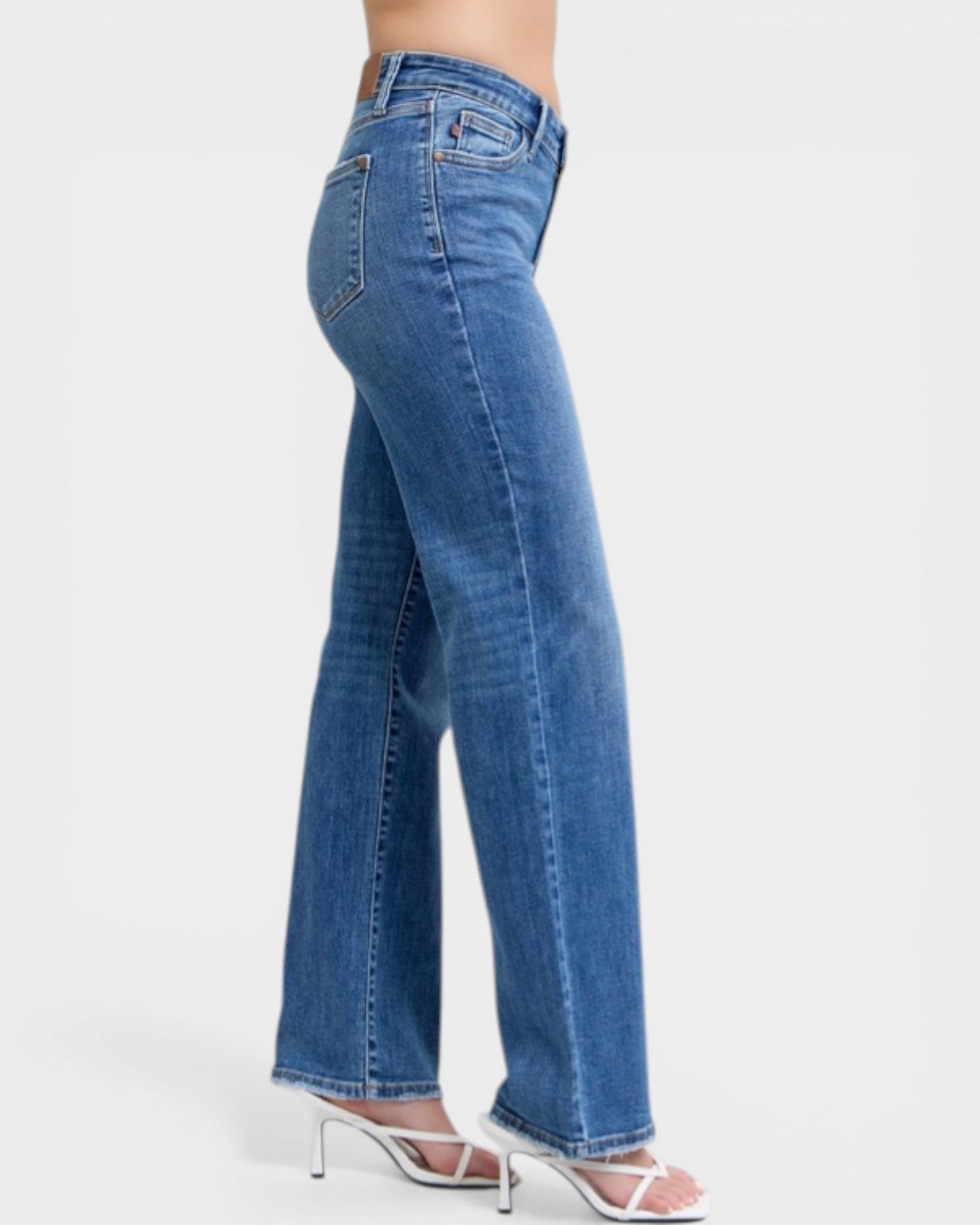 Blue jeans worn by a person on a white background