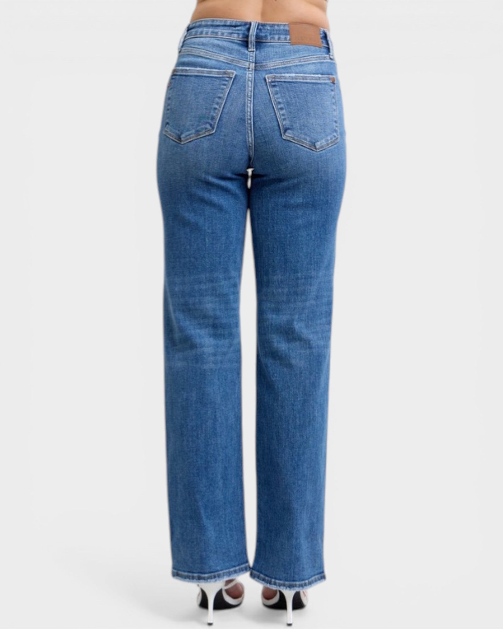 Blue jeans worn by a person on a white background