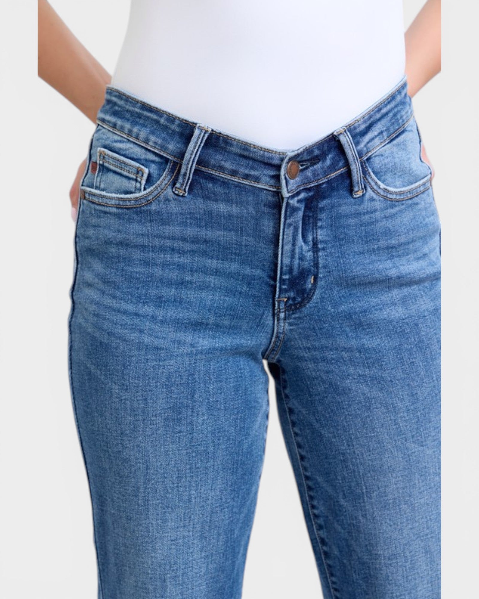 Blue jeans worn by a person on a white background