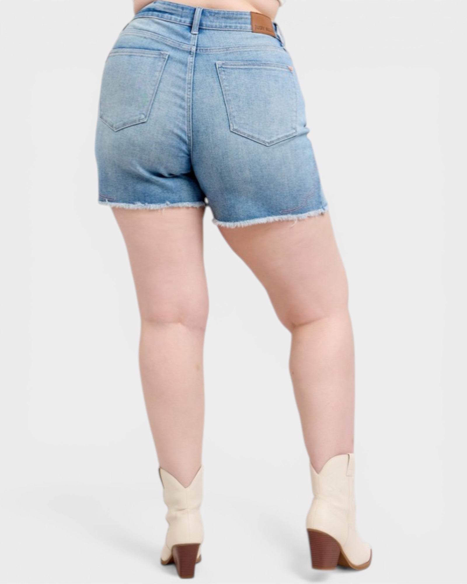 Person wearing light blue denim shorts on a white background