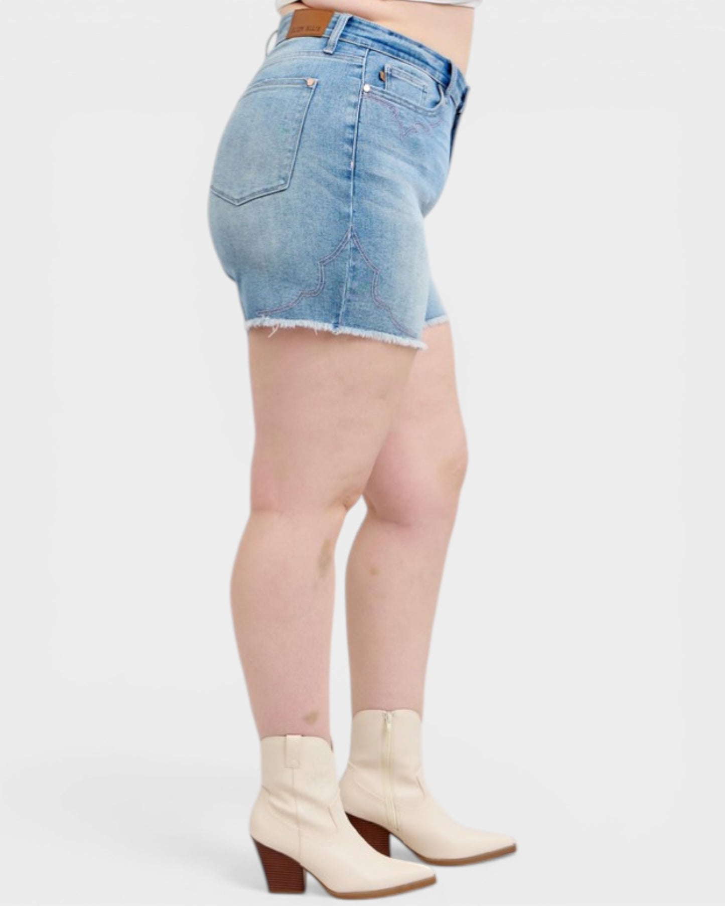 Denim shorts worn by a person on a white background
