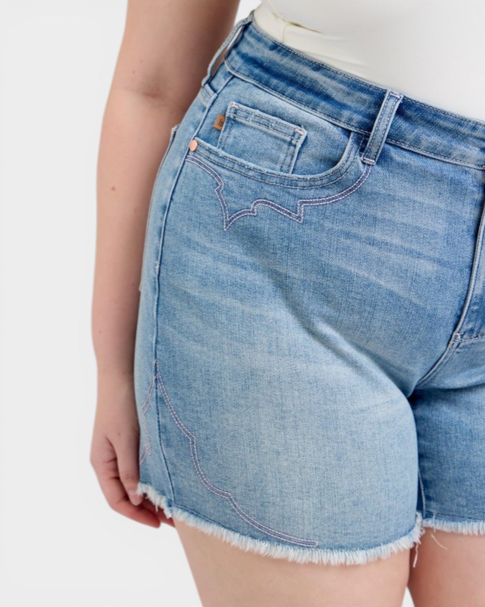 Close-up of blue denim shorts on a white background
