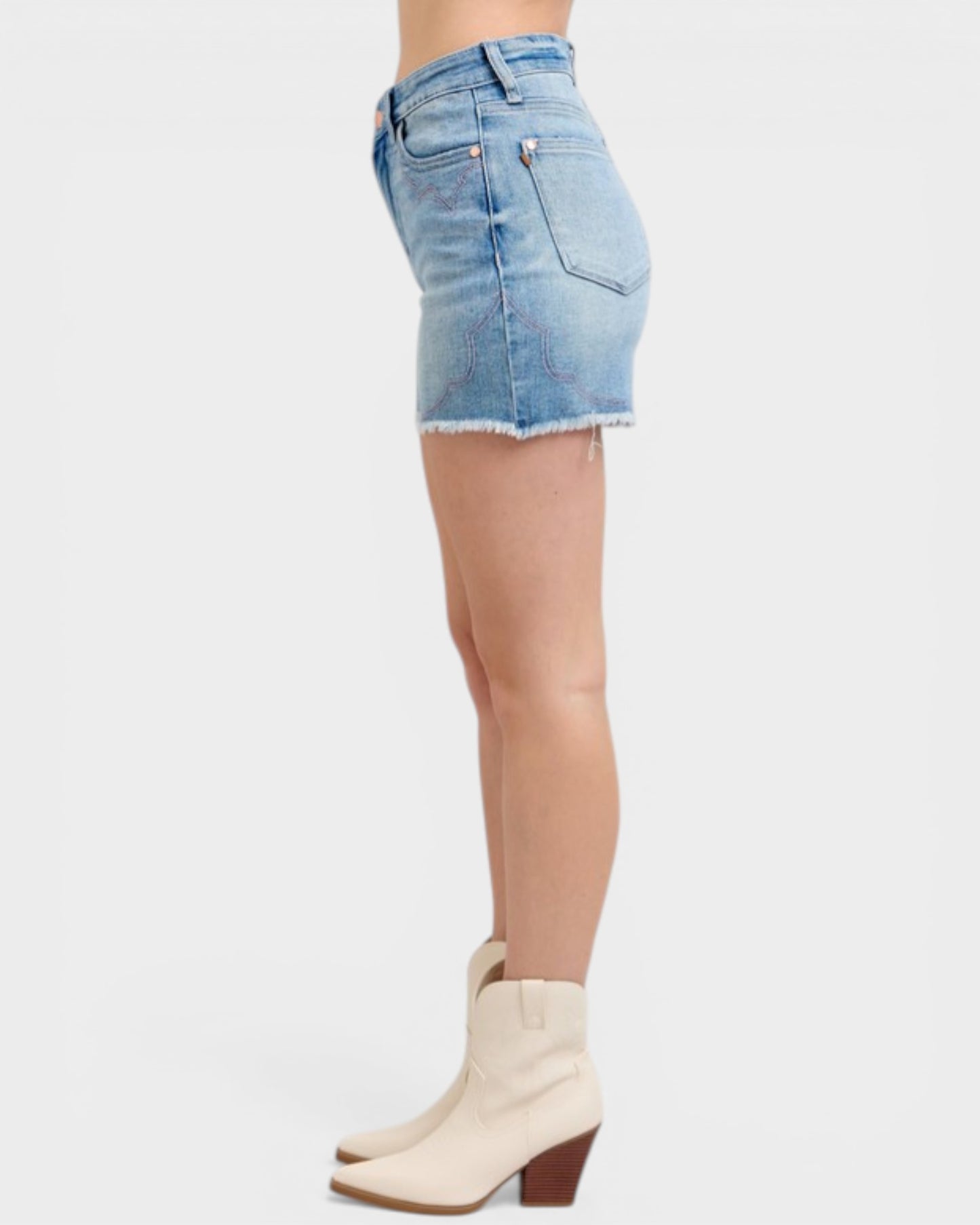 Denim skirt worn by a person on a white background
