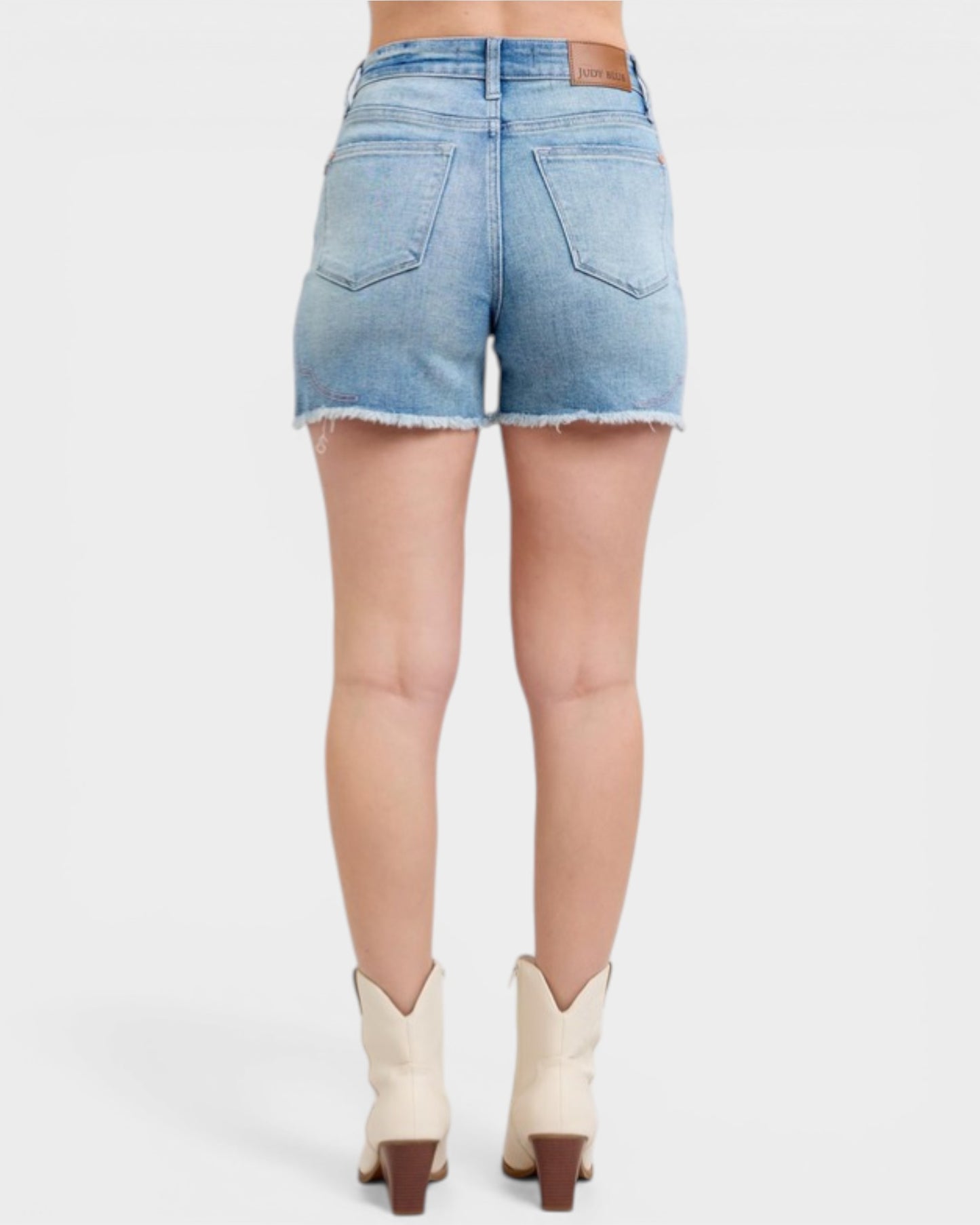 Denim shorts worn by a person on a white background