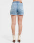 Denim shorts worn by a person on a white background