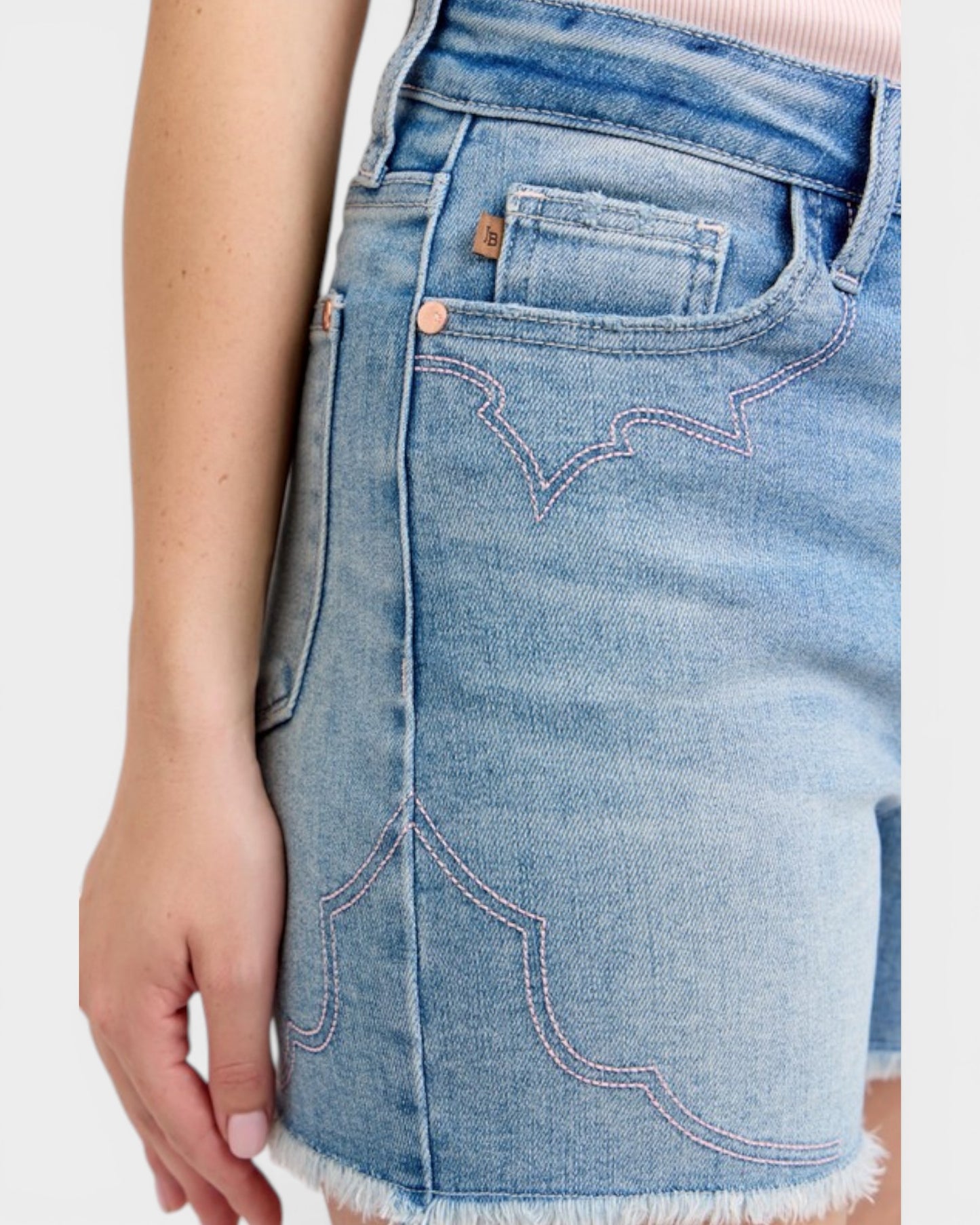 Close-up of a person wearing denim shorts on a white background