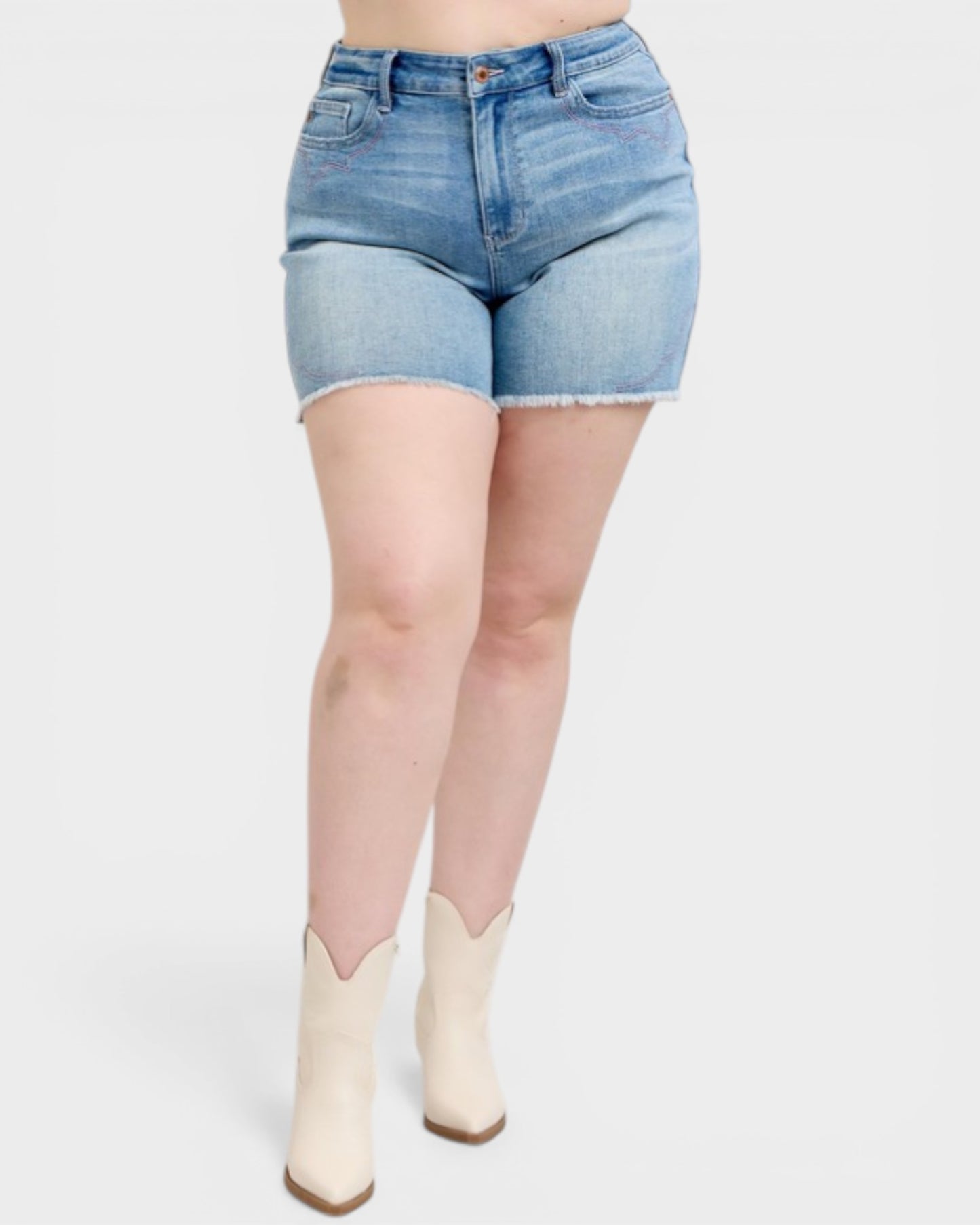 Person wearing light blue denim shorts and white boots on a white background