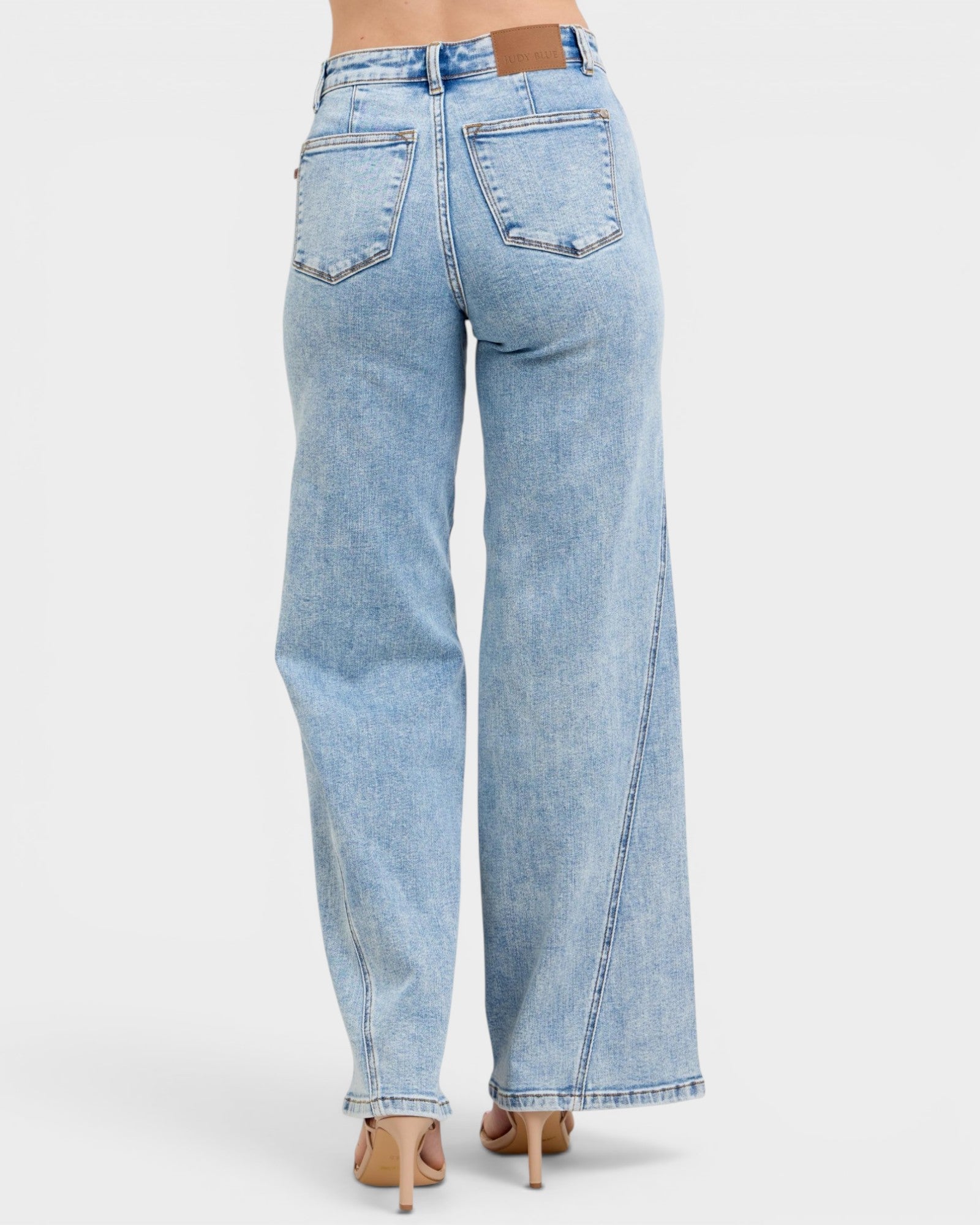 Light blue jeans worn by a person on a white background