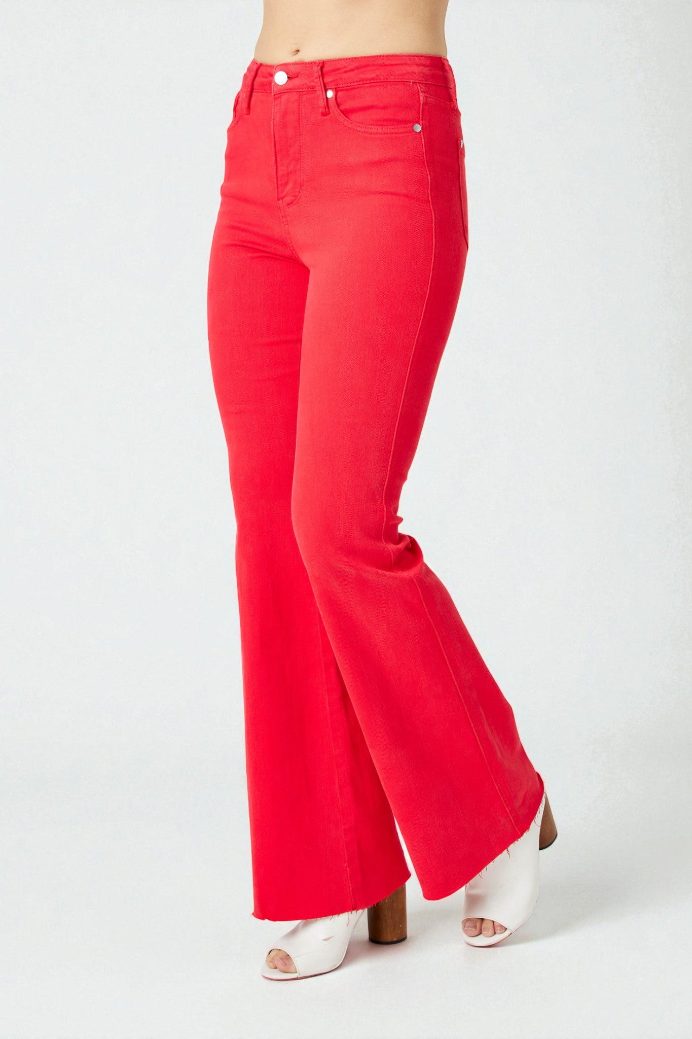 Red flared jeans worn by a person on a white background
