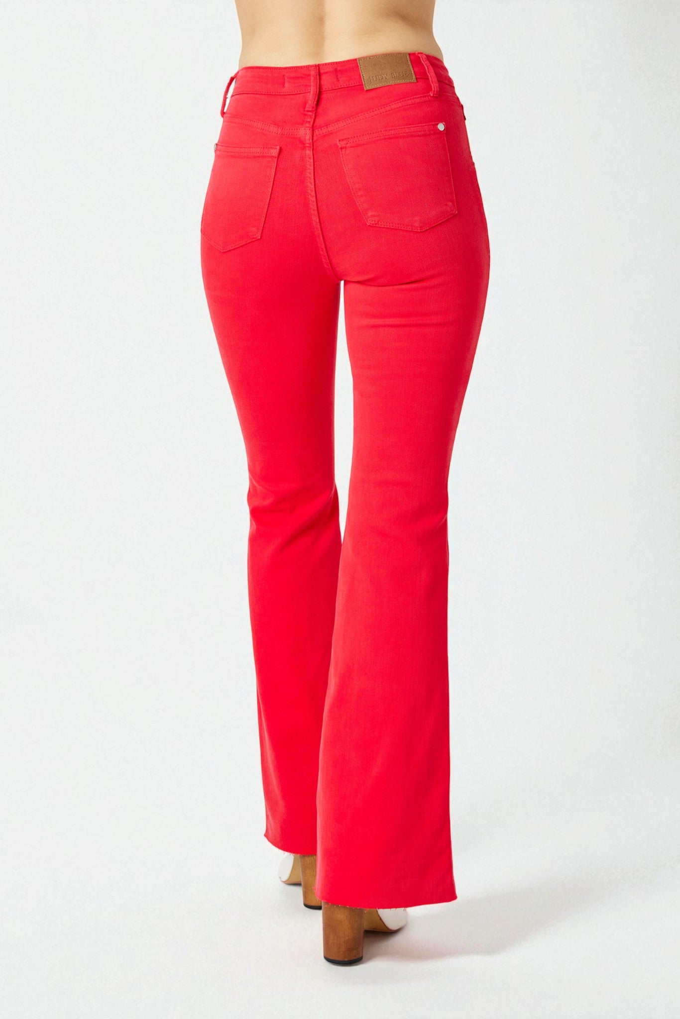 Red jeans with a brown patch on a white background