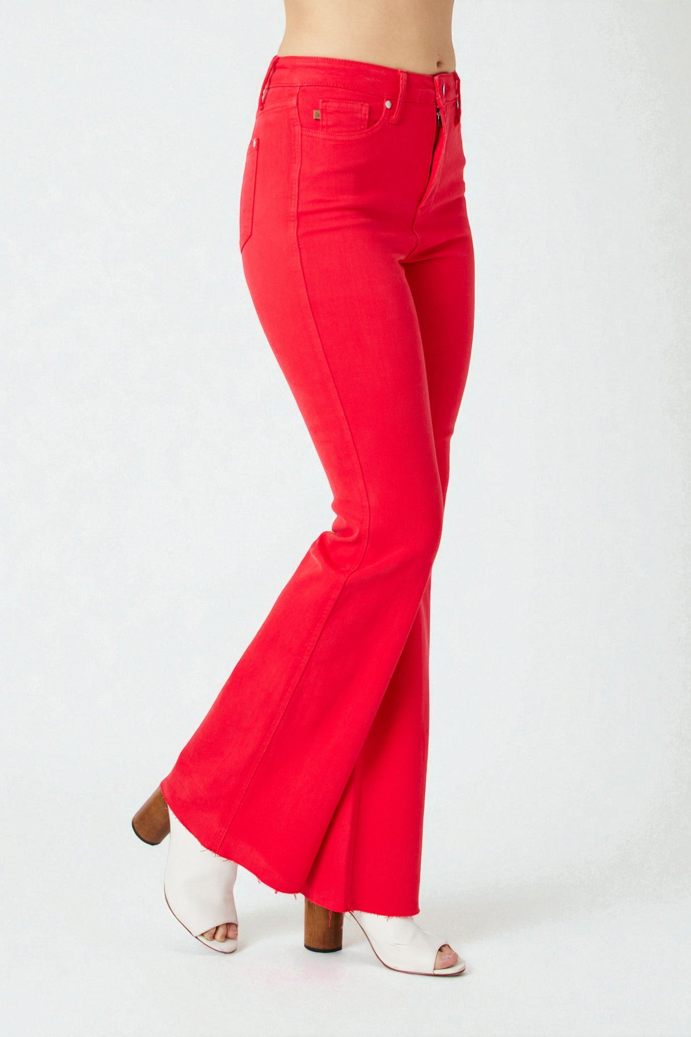 Red flared jeans worn by a person on a white background