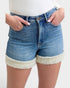 Denim shorts with white Sherpa lining worn by a person on a plain background