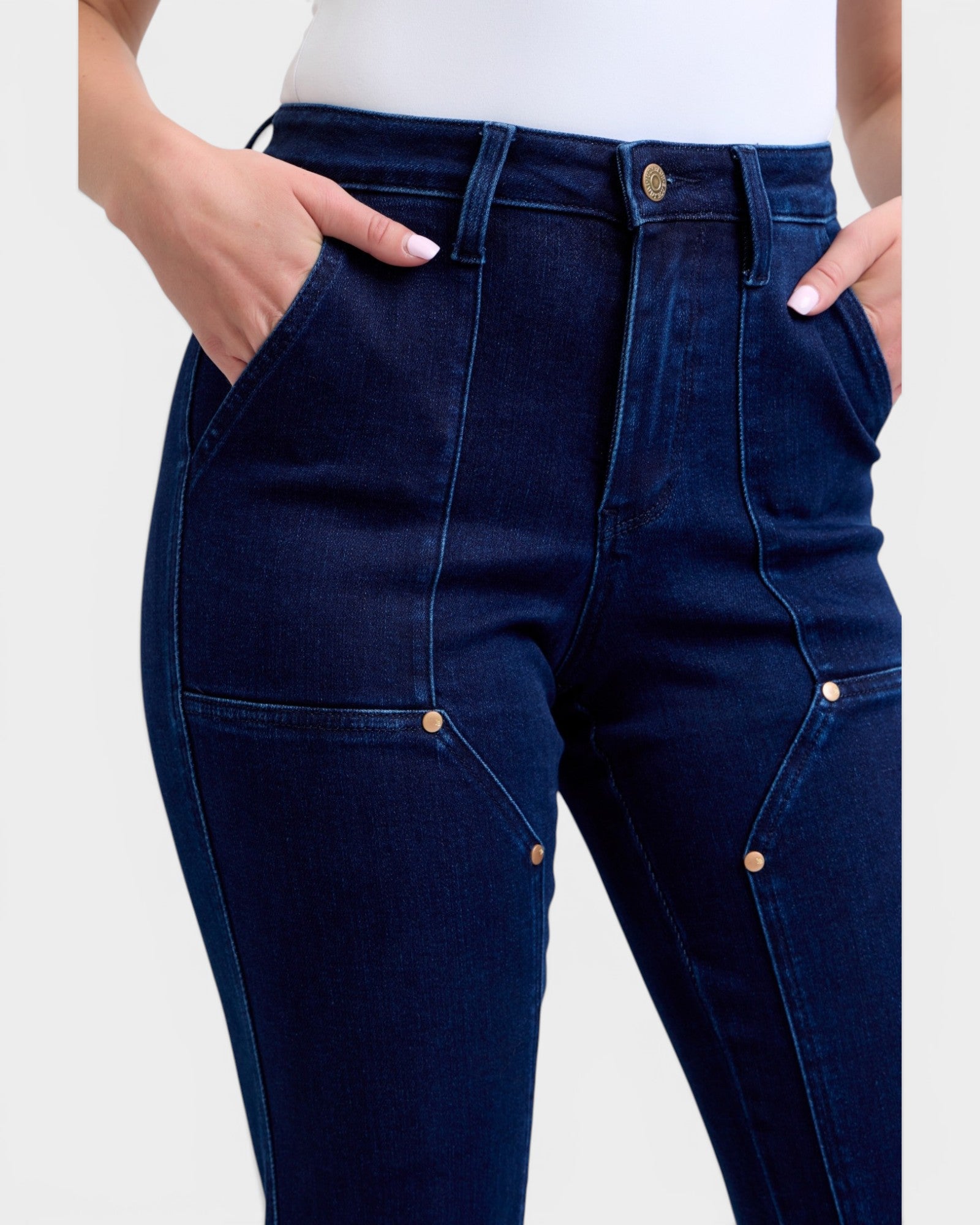 Navy blue jeans worn by a person on a white background