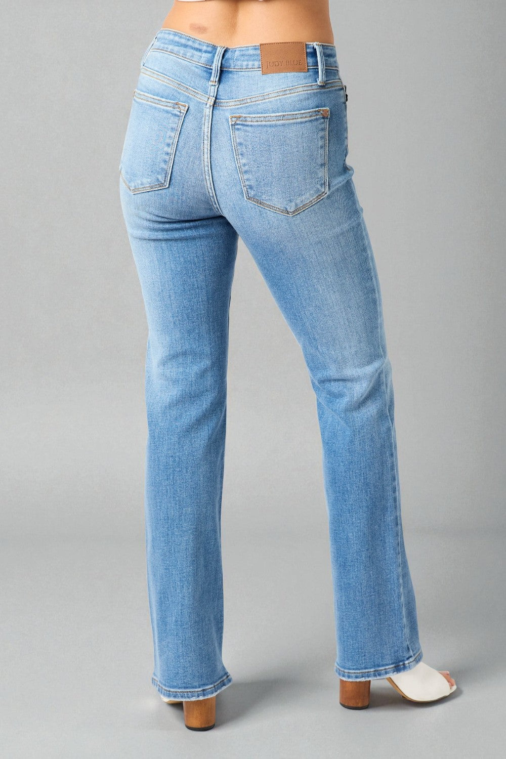 Light blue jeans worn by a person on a gray background