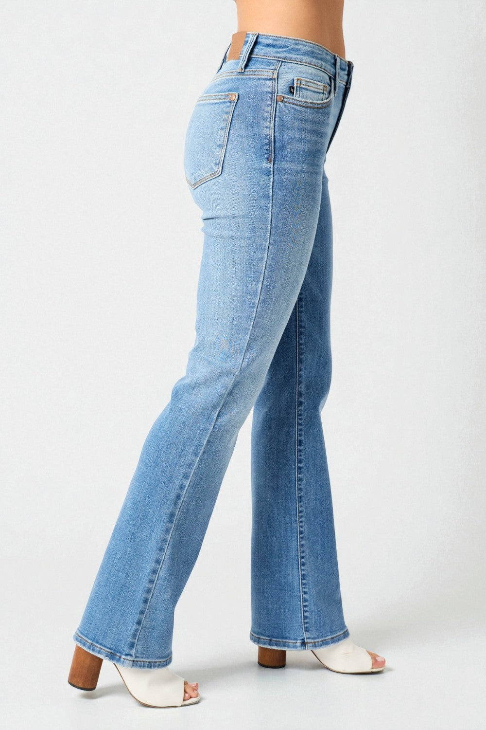 Blue jeans worn by a person on a white background