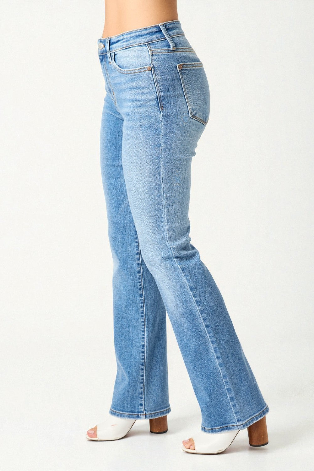 Light blue flared jeans worn by a person on a white background