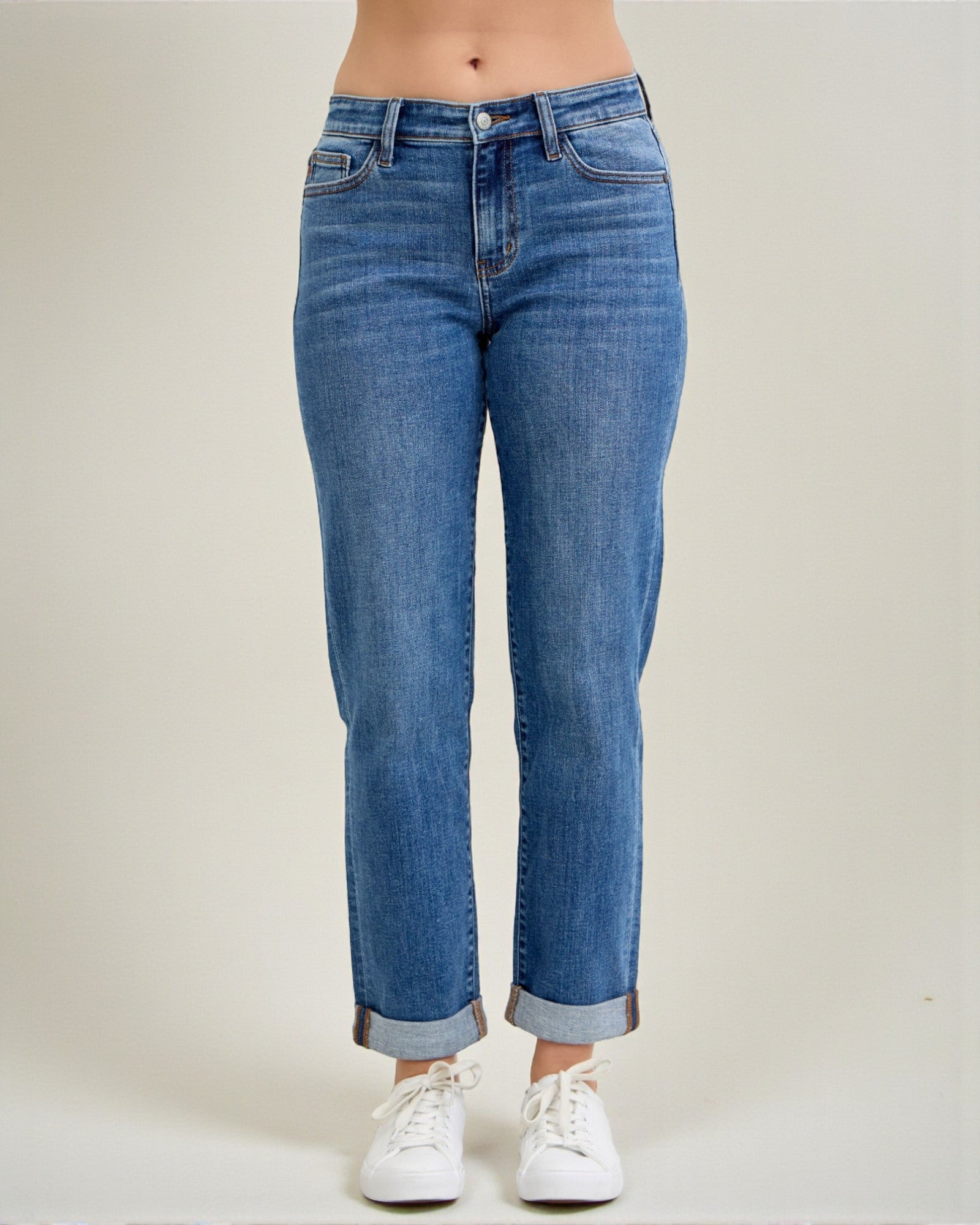 Blue jeans worn by a person on a plain background