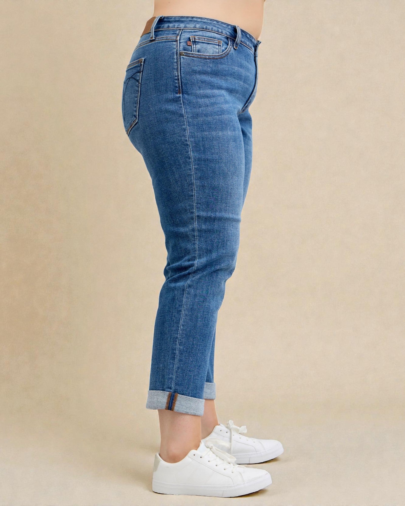 Blue jeans worn by a person on a beige background