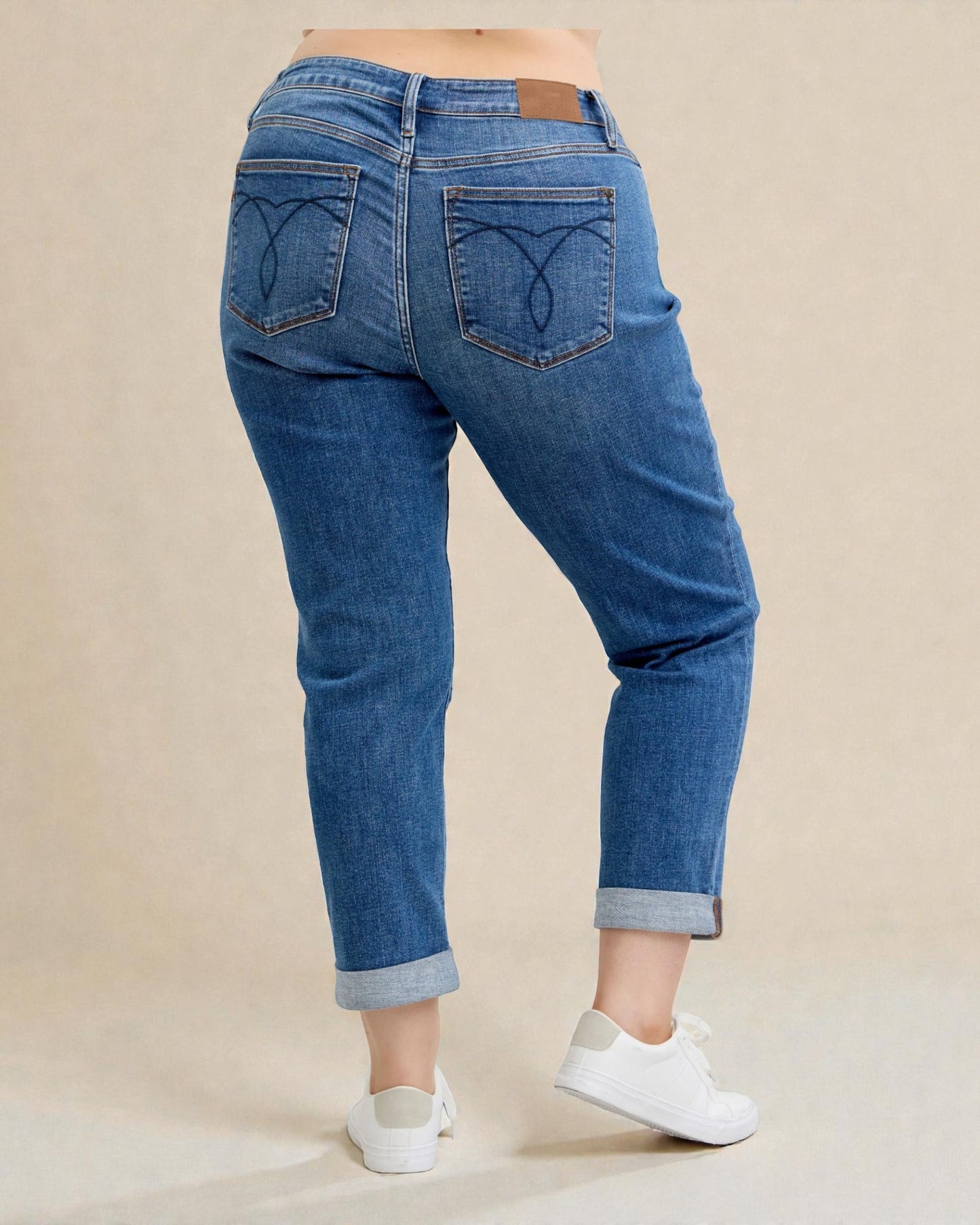 Person wearing blue jeans with a beige background