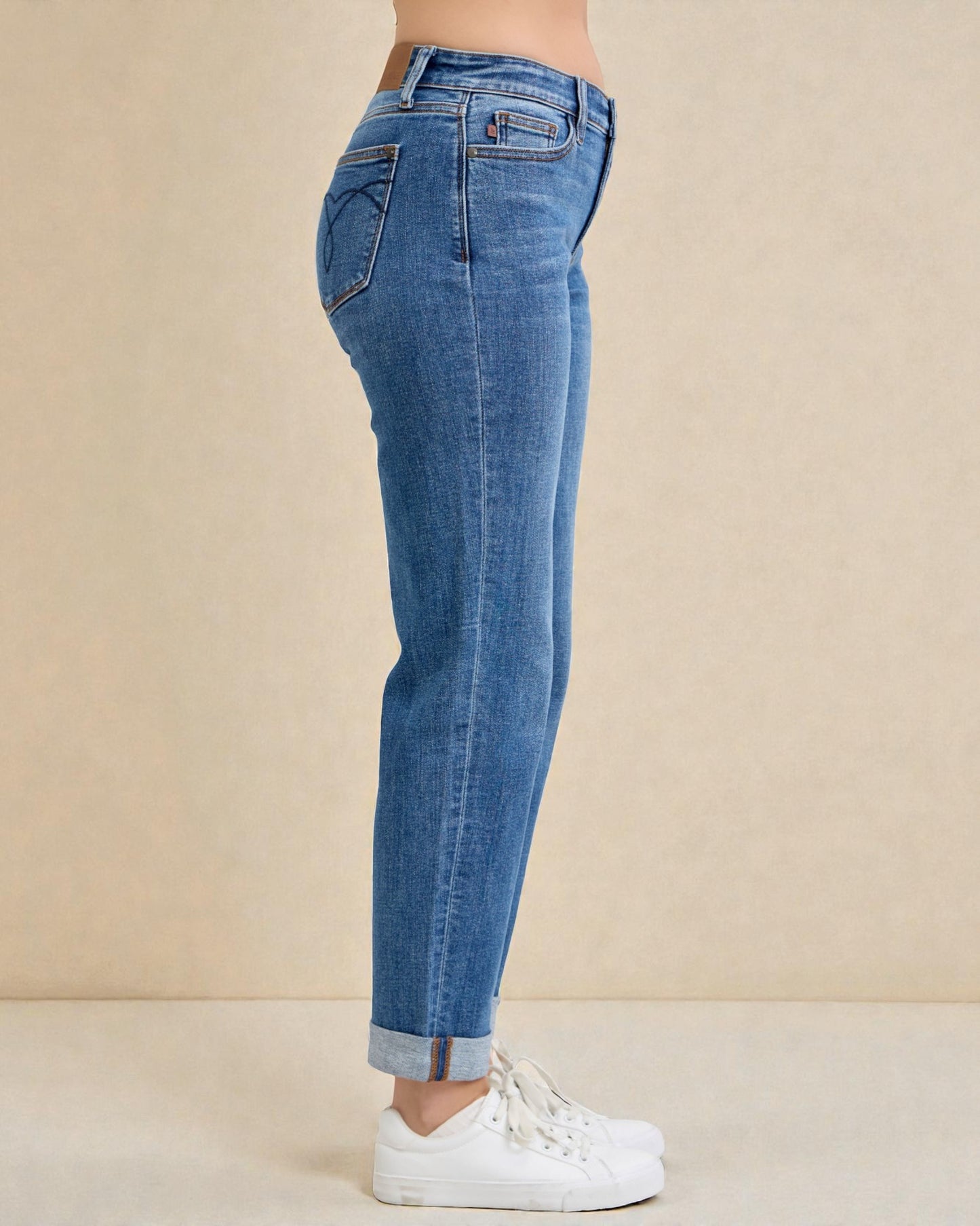 Blue jeans worn by a person on a beige background