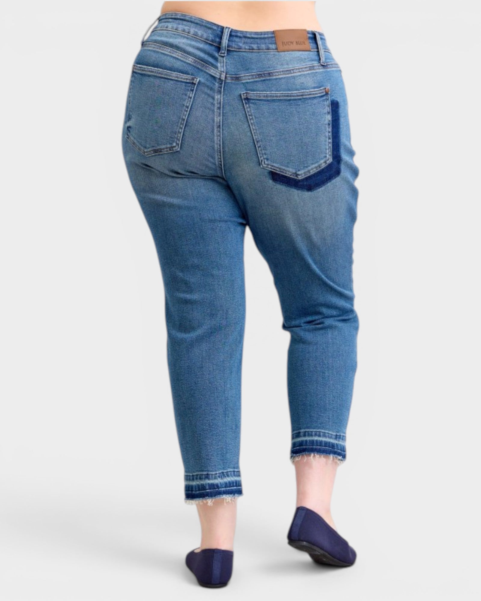 Blue jeans worn by a person on a white background