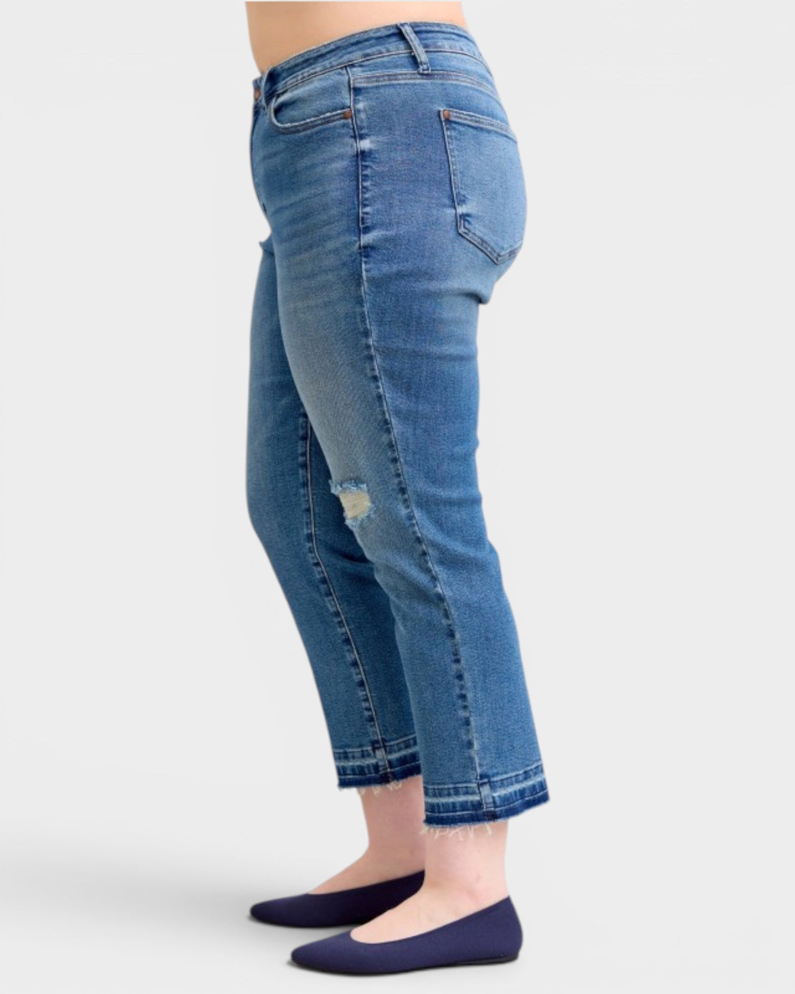 Blue jeans worn by a person on a white background