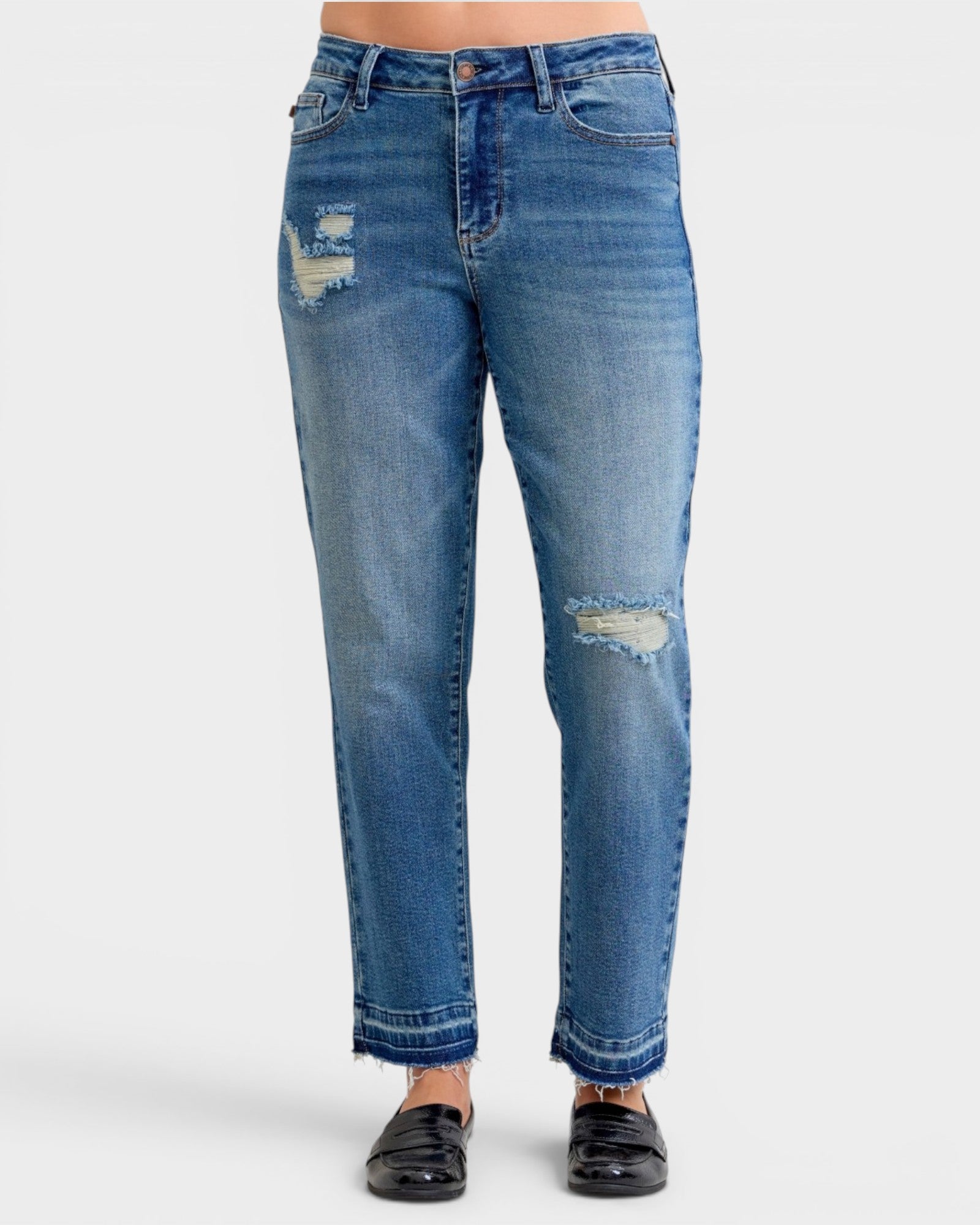 Blue jeans with distressed details on a white background