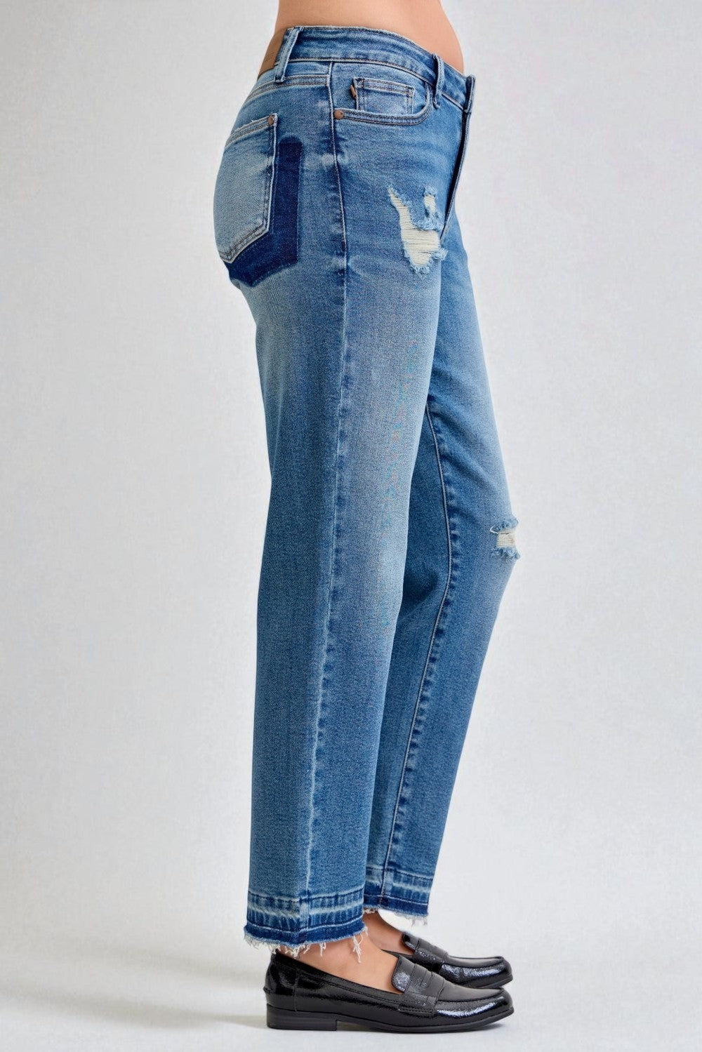 Blue jeans with distressing details on a plain background