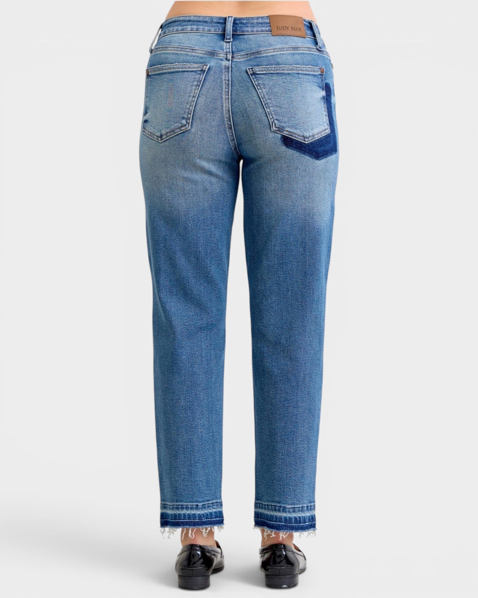 Blue jeans worn by a person on a white background