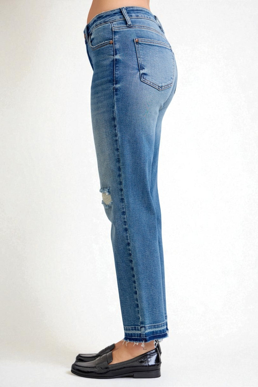 Blue jeans worn by a person on a white background