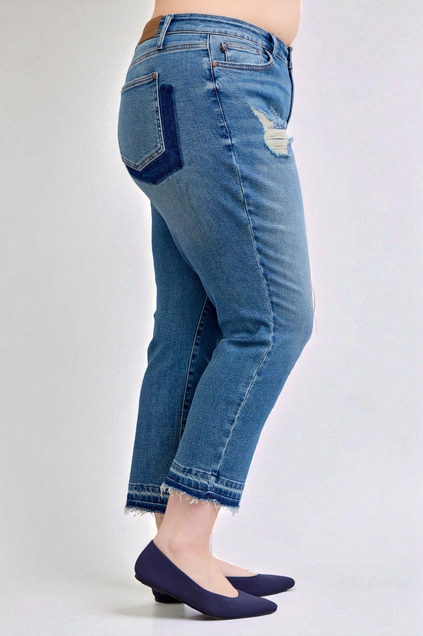 Blue jeans worn by a person on a white background
