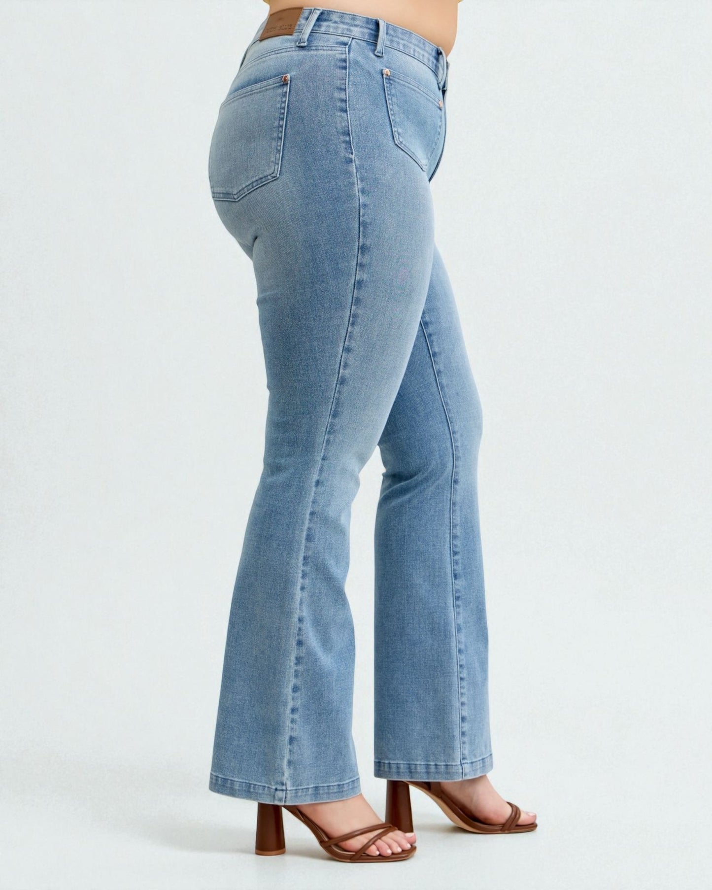 Light blue flared jeans worn by a person on a white background