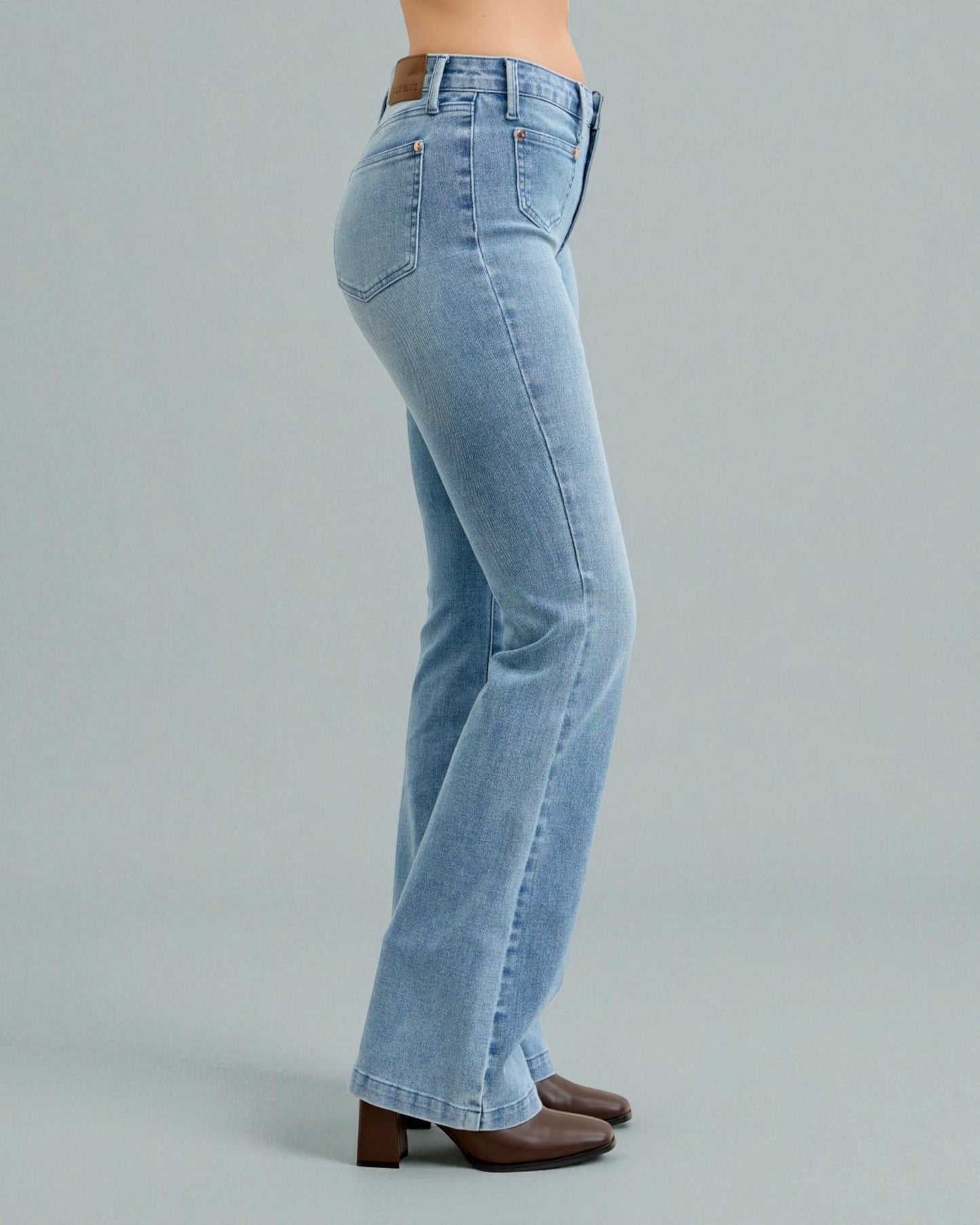 Light blue jeans worn by a person on a gray background