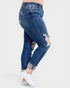 Blue distressed jeans worn by a person on a white background