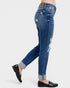 Blue jeans with a slight distressed look worn by a person on a white background
