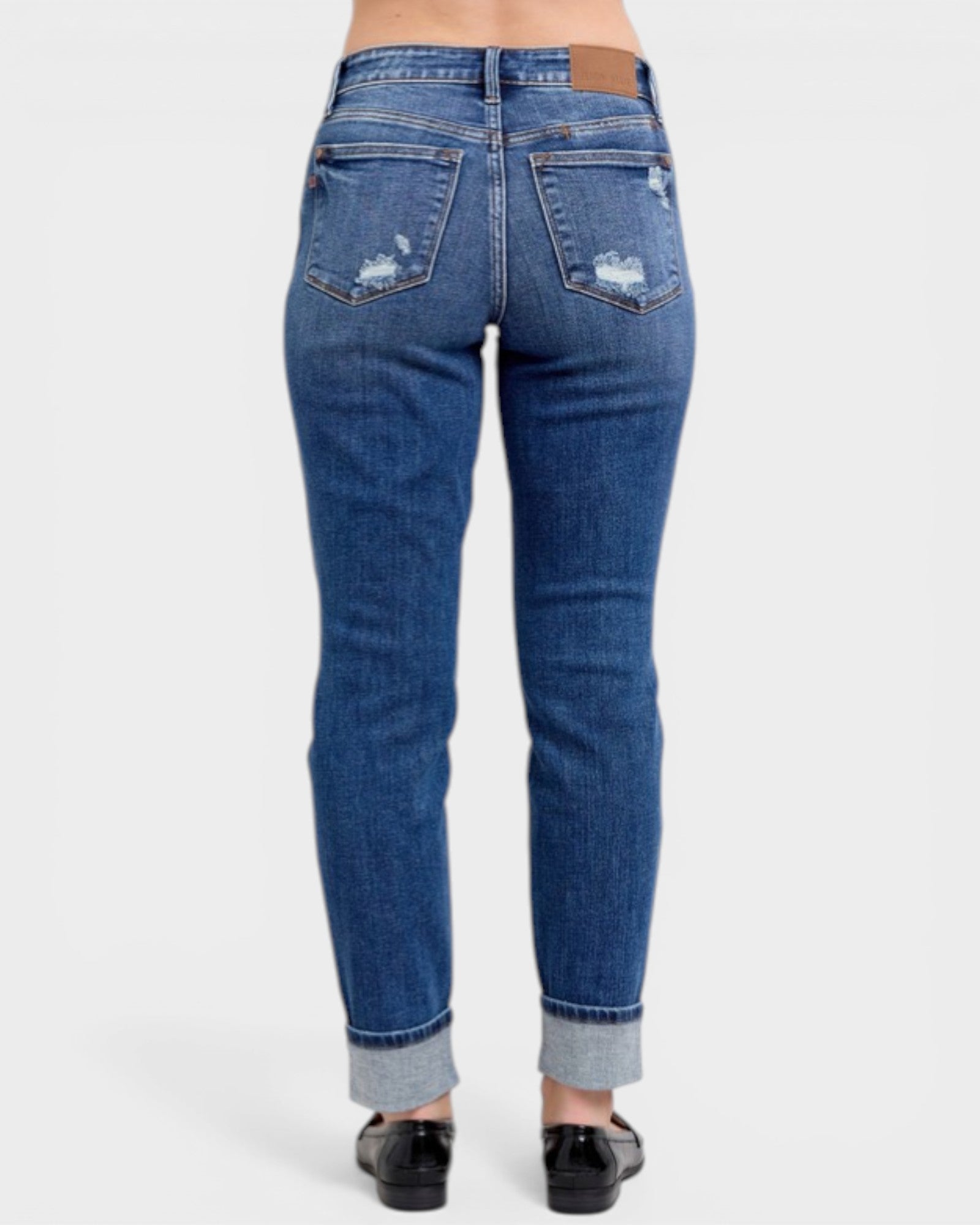 Blue jeans with distressed details on a white background