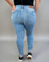 Person wearing light blue jeans on a plain background