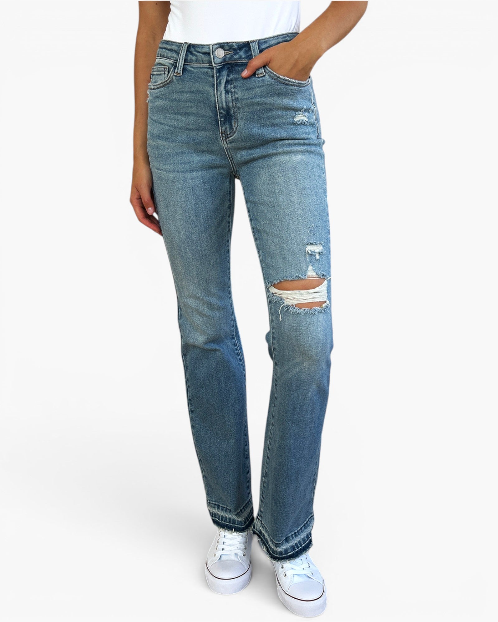 A person wearing light blue high-waisted distressed jeans with ripped details on the thighs, paired with a white top and white sneakers, shown against a plain white background.