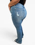 A person wearing medium-wash blue denim jeans with a distressed back pocket detail, shown from a side-rear angle against a plain light background.