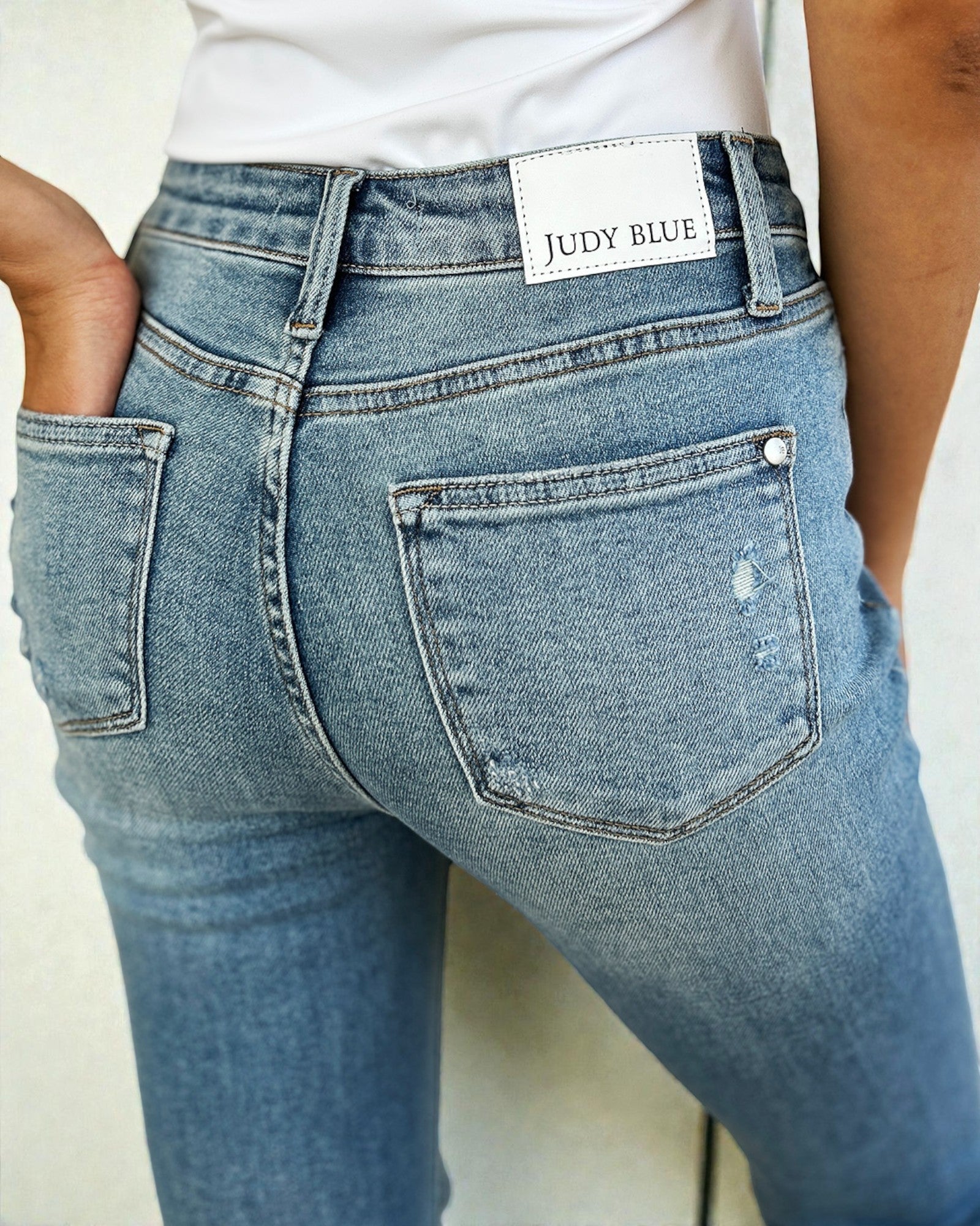 Blue jeans with a Judy Blue label on a plain background
